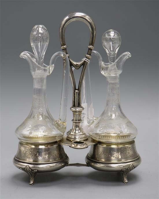 A pair of glass oil and vinegar bottles and stoppers in an Austro Hungarian white metal stand, 24.6cm.